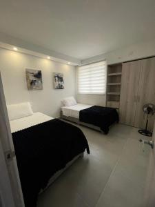 een slaapkamer met twee bedden en een raam bij Exceptional apartment to rest in Cartagena
