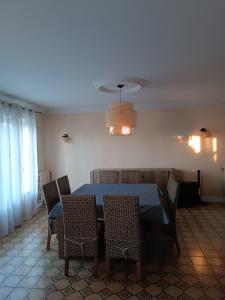 una sala da pranzo con tavolo e sedie blu di Maison proche circuit 24h ad Arnage