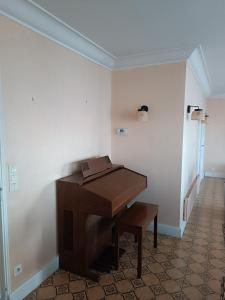 un pianoforte di legno in una stanza con un corridoio di Maison proche circuit 24h ad Arnage