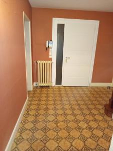 una stanza vuota con una porta e un pavimento piastrellato di Maison proche circuit 24h ad Arnage 1 altra foto