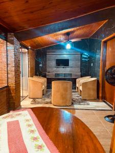 a room with a table and chairs and a television at Recanto orti in Olímpia