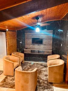a room with chairs and a flat screen tv at Recanto orti in Olímpia