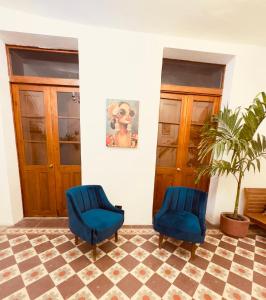 two blue chairs in a room with a plant at Lartbook Mty in Monterrey
