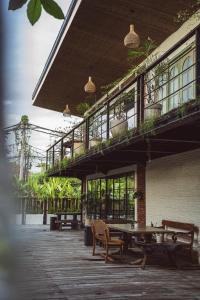 un patio con un tavolo e un balcone con piante di White Penny Hostel a Seminyak