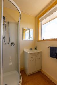 une salle de bain avec douche et lavabo dans l'établissement Foxton Beach Bach 5 Star Location 2 Min Walk To Beach New Furnishings BBQ, à Foxton Beach 72 autres photos