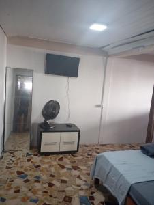 una camera da letto con un letto e una TV a parete di Flats Beira mar casal a Penha