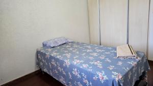 a small bed in a room with a blue blanket at Pousada Shanti Quarto 3 in Dourados