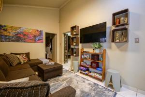 a living room with a couch and a tv at Just Dandee in Naboomspruit