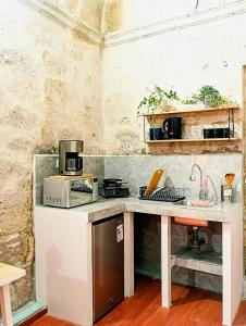 a kitchen with a counter with a microwave and a sink at Colonial San Lazaro Apart Hotel in Arequipa