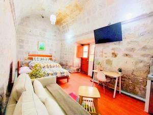 a bedroom with a bed and a couch and a table at Colonial San Lazaro Apart Hotel in Arequipa