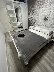 een slaapkamer met een bed en een grote spiegel bij Spacious apartment with a beautiful view in Căuşeni