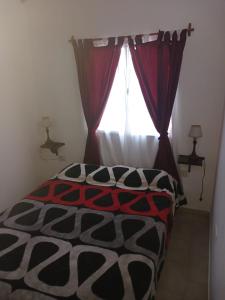 a bedroom with a bed in front of a window at Casa ruau in Valeria del Mar