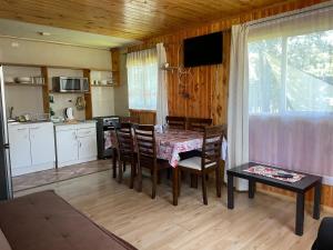 a kitchen and dining room with a table and chairs at La Comarca in Hornopiren