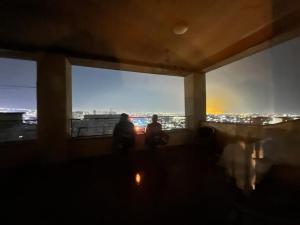 two people sitting in a room with a view of the city at Noah's sunlight villa hostel in Yerevan