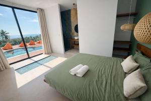 une chambre avec un lit et une vue sur une piscine dans l'établissement NAHA Villa Sea View Koh Phangan, à Baan Tai