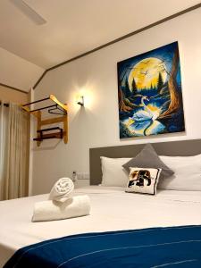 een slaapkamer met een bed met een schilderij aan de muur bij Hiri Point Villa in Dikwella +33 foto's