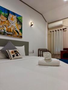 een slaapkamer met een wit bed met een schilderij aan de muur bij Hiri Point Villa in Dikwella