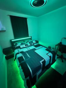 una camera con letto e luce verde di Modern Theme Private Room a Suffolk