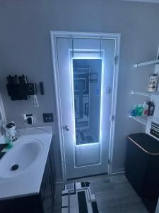 un bagno con lavandino e doccia con specchio di Modern Theme Private Room a Suffolk Altre 28 foto