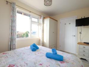 - une chambre avec un lit et des chaussons bleus dans l'établissement Merlin's Retreat, à Tintagel