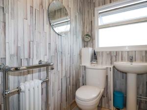 une salle de bains avec toilettes, lavabo et miroir dans l'établissement Merlin's Retreat, à Tintagel 15 autres photos