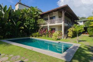 a villa with a swimming pool in front of a house at Tortuga HBH in Playa Hermosa