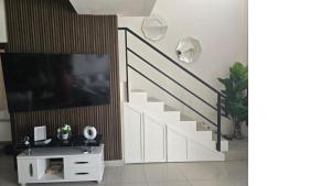 ein Wohnzimmer mit einer Treppe und einem TV in der Unterkunft Beutiful New Villa In Punta Cana in Punta Cana