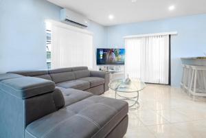 un salon avec un canapé et une table en verre dans l'établissement The Dorset on Ashby, à Chaguanas Village