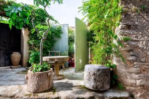 un giardino con due grandi vasi di pietra e una panchina di Romantic Provence Pool & Mill View a Goult