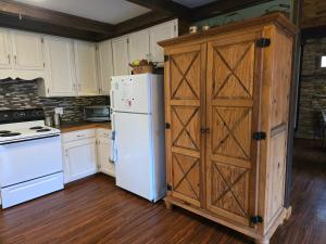 une cuisine avec un réfrigérateur blanc et une armoire en bois dans l'établissement Hummingbird Hideaway - Lake Pets Hike Fish, à Hidetown 14 autres photos