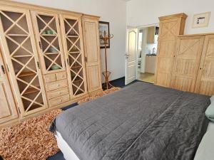 a bedroom with a bed and a large wooden cabinet at Apartmán Vintage A2 v Chomutově in Chomutov