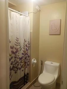 a bathroom with a toilet and a shower curtain at 316 Tower 3 Avida Atria Iloilo Pool View Comfy Cozy Central in Iloilo City