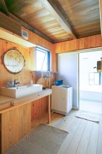 een badkamer met een wastafel en een spiegel aan de muur bij マーレゲストハウス in Fukui +101 foto's