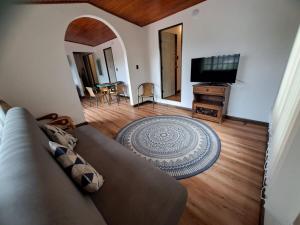 a living room with a couch and a flat screen tv at El Embeleso in Nobsa