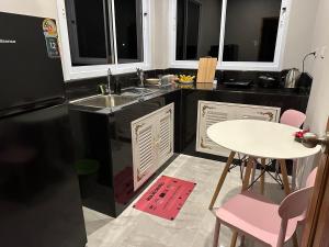 een keuken met een witte tafel en een zwarte koelkast bij Hill View Home 3 in Ko Pha Ngan