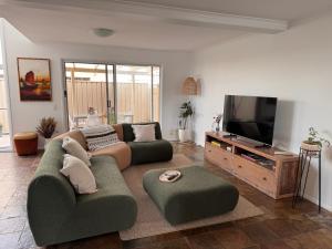 un soggiorno con divano e TV a schermo piatto di The Mooloolaba Terrace a Mooloolaba