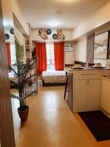 a kitchen with red curtains and a bedroom with a bed at 319 Tower 4 Avida Atria Iloilo Comfy Cozy Central Studio Unit in Iloilo City +22 photos
