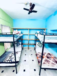 een kamer met 3 stapelbedden en een plafondventilator bij Hostel Desert Routes in Jaisalmer