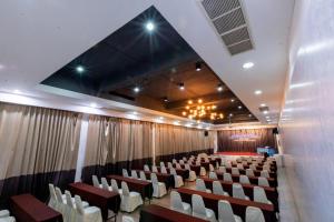 een conferentiezaal met witte stoelen en een podium bij Royal Diamond Hotel in Phetchaburi +9 foto's
