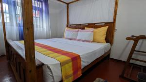 een slaapkamer met een bed met een houten frame bij Bay Beach dom stay in Tangalle