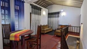 een woonkamer met een tafel, stoelen en een bank bij Bay Beach dom stay in Tangalle