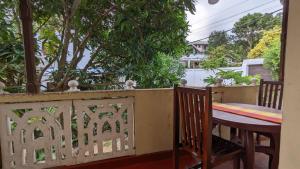 een houten tafel en stoelen op een balkon bij Bay Beach dom stay in Tangalle