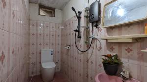een roze badkamer met een toilet en een wastafel bij Bay Beach dom stay in Tangalle
