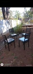 three empty chairs sitting next to a wall at Aarex 63B Sparsh Chalet in Dhamni +3 photos