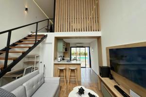 un salon avec un canapé et une cuisine dans l'établissement Tiny House con Piscina Privada, Jacuzzi, Parrilla y Starlink, à Punta Negra