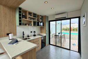 une cuisine avec vue sur une piscine dans l'établissement Tiny House con Piscina Privada, Jacuzzi, Parrilla y Starlink, à Punta Negra