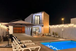 une maison avec piscine la nuit dans l'établissement Tiny House con Piscina Privada, Jacuzzi, Parrilla y Starlink, à Punta Negra