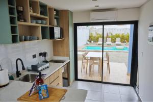 - une cuisine avec une table et une vue sur la piscine dans l'établissement Tiny House con Piscina Privada, Jacuzzi, Parrilla y Starlink, à Punta Negra