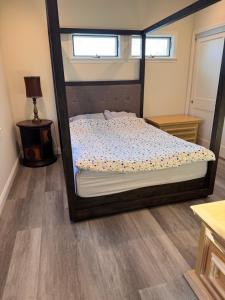 ein Schlafzimmer mit einem Bett mit einem großen Holzrahmen in der Unterkunft Modern 3BR Condo with 2-Car Garage in Pasadena