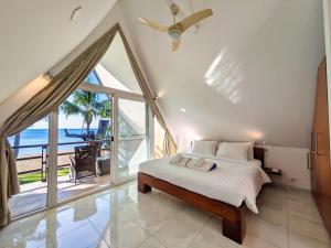a bedroom with a bed and a large window at Five Palms Beachfront Villa - by KohChangVillas in Ko Chang